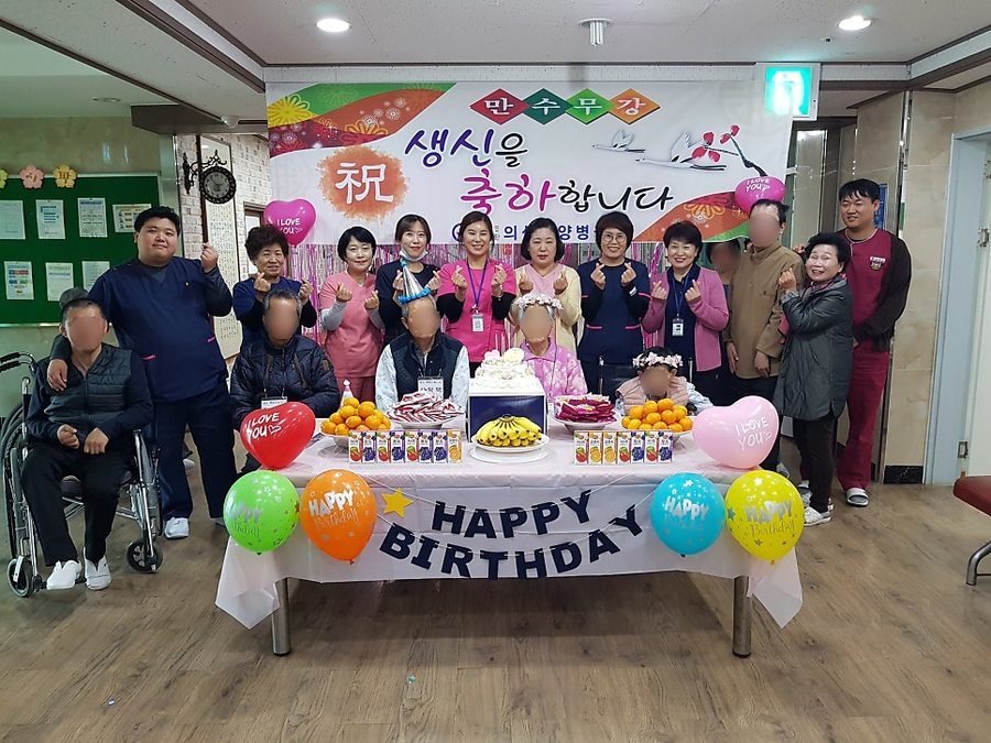 생신 축하 잔치에서 어르신들과 직원들이 함께 찍은 단체 사진