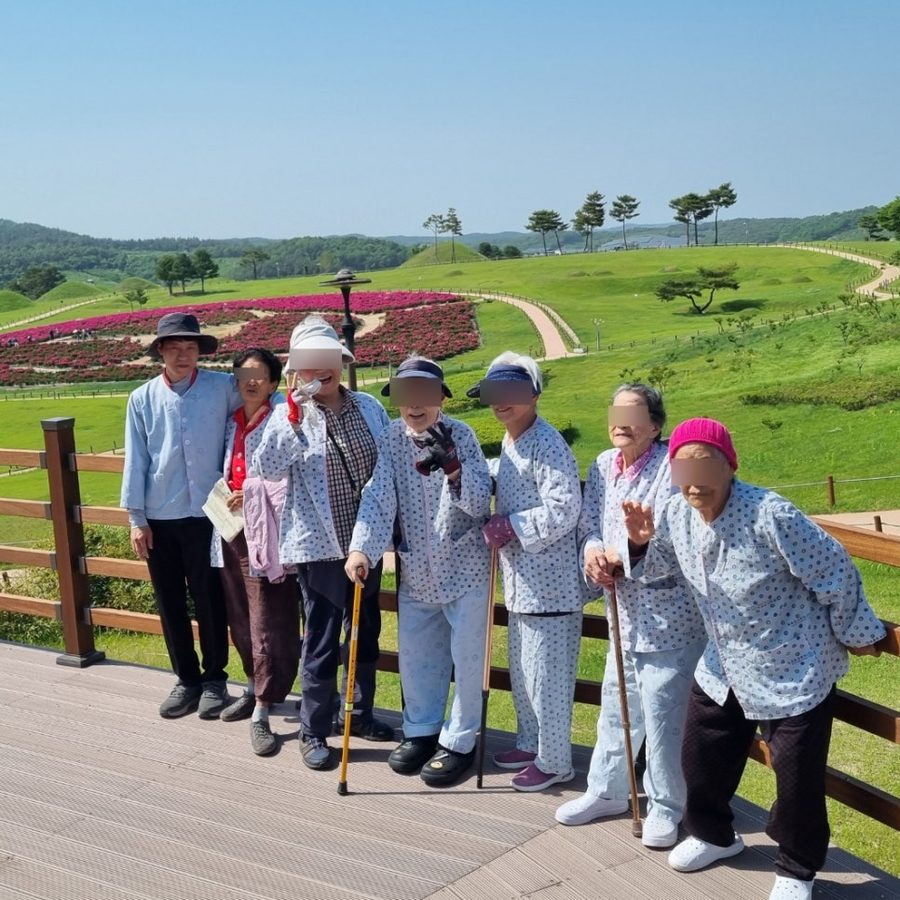 어르신들과 직원들이 꽃동산 나들이에서 함께 찍은 사진